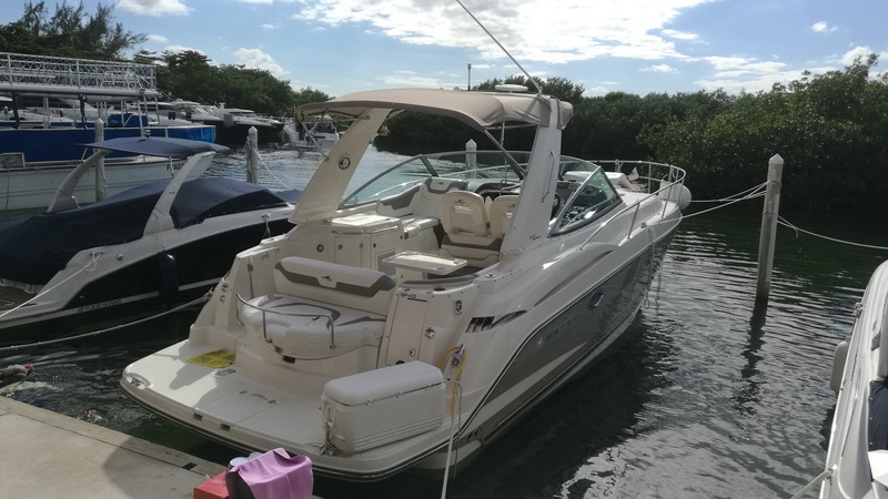 Yate de lujo Monterrey atracado en la marina de Cancún, vista de popa con espaciosa cabina abierta y asientos blancos