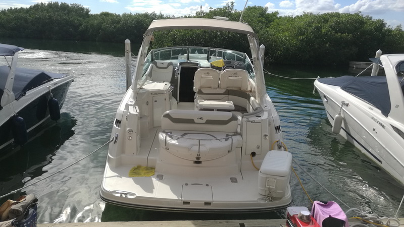 Cabina de popa del yate Monterrey con asientos blancos y helm station en la marina de la laguna de Cancún para charter