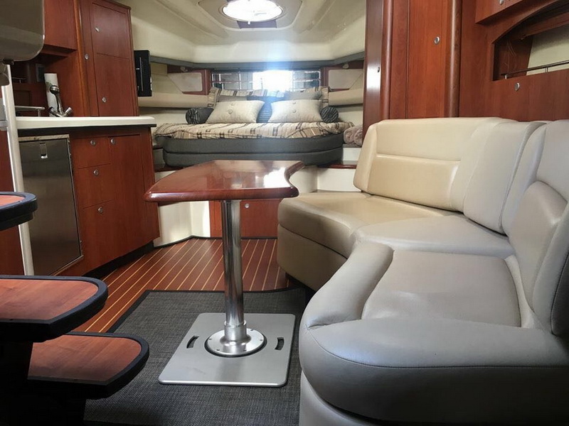 Lujoso salón interior del yate Monterrey con mesa de teca y sofá de cuero para huéspedes de charter en Cancún