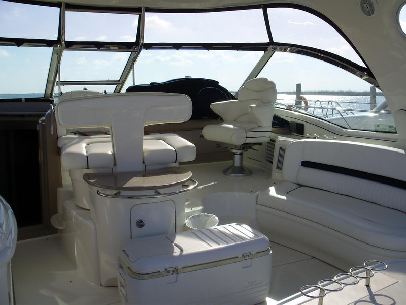 Cockpit helm area of Sea Horse 56 ft yacht with captain's chair, sofa seating and panoramic windshield views