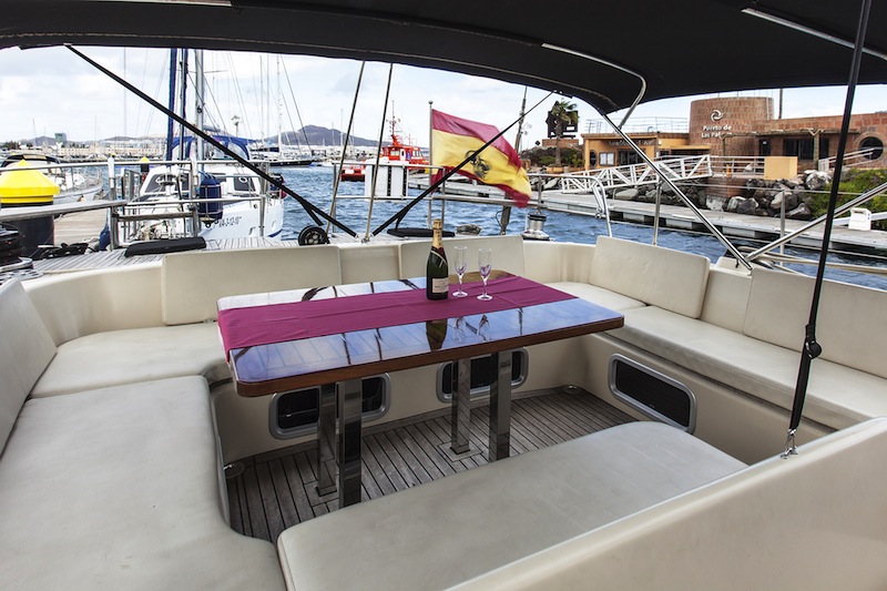 Bañera en U con champán y copas en mesa de teca del motor-velero Zulu de 66 pies, charter privado de lujo Cancún