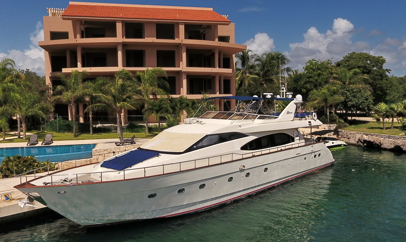 85 ft Azimut luxury yacht docked at a Riviera Maya marina with palm trees and emerald water, premium Cancun yacht charter