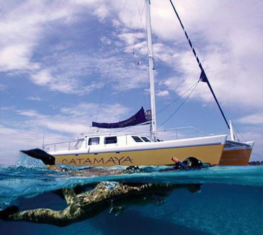 Catamaya catamaran side profile sailing turquoise Caribbean waters Riviera Maya snorkel tour