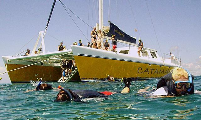 Guests snorkeling at Riviera Maya reef turquoise water Caribbean Catamaya catamaran charter