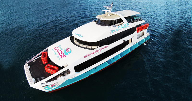 catamarán Barcos Caribe, blanco y turquesa, cruzando el mar azul profundo entre Playa del Carmen y Cozumel