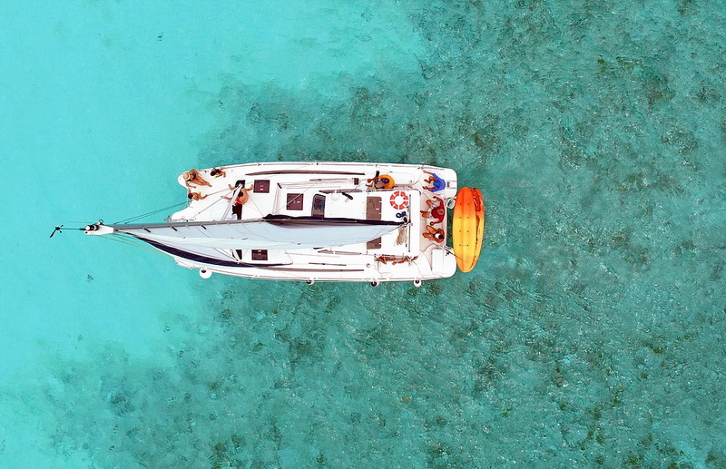 Huéspedes navegando el catamarán Gemini por la costa de Cozumel en un día tranquilo y soleado