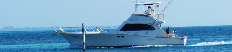 Hatteras 48 Querida del Mar fishing charter yacht underway in turquoise Caribbean Sea Cancun