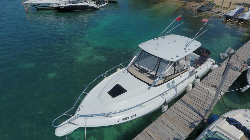Vista cenital del bote de pesca Intrepid 32 amarrado a un muelle de madera sobre agua turquesa poco profunda cerca de Cancún