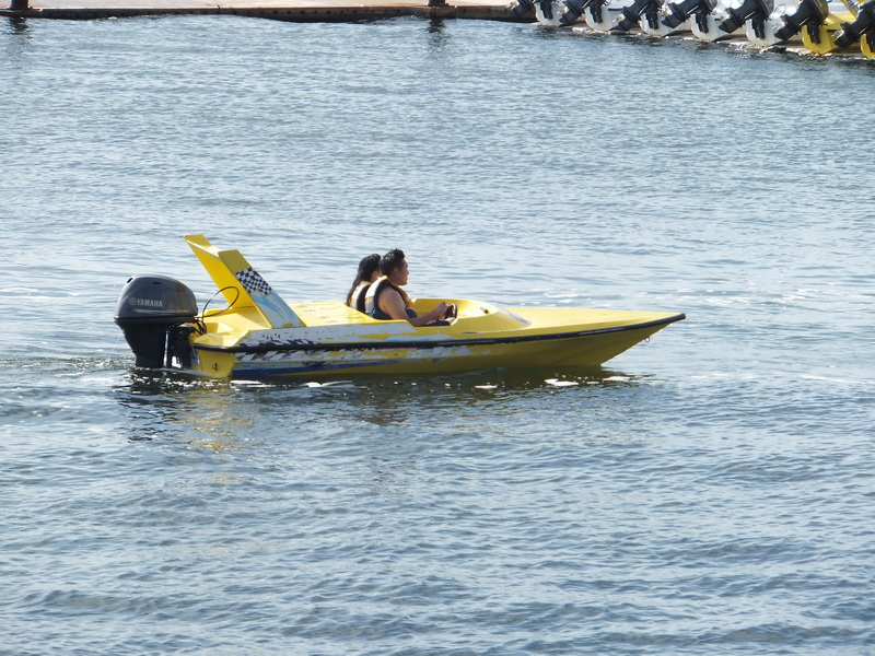 Dos invitados manejando una lancha rápida amarilla de dos personas del jungle tour con motor Yamaha por la tranquila Laguna Nichupté en Cancún