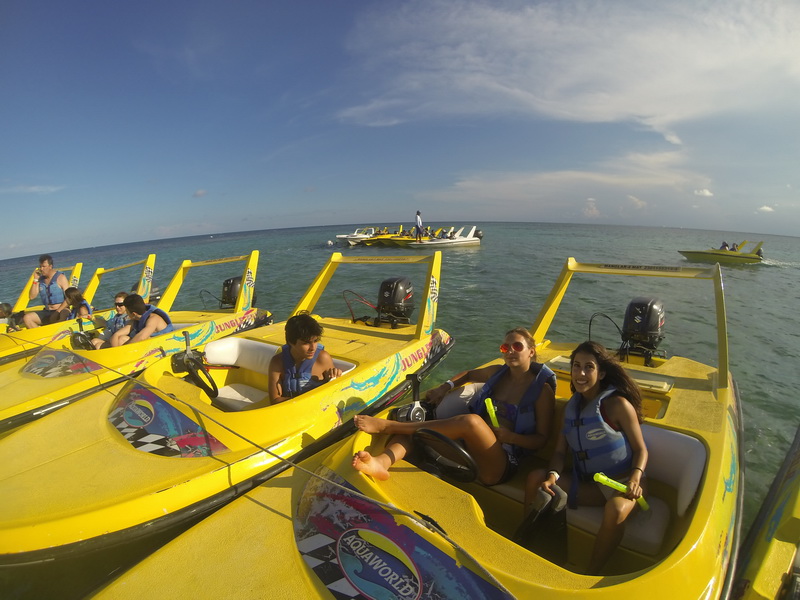 Lanchas rápidas amarillas del Jungle Tour con familias en chalecos salvavidas sobre el arrecife turquesa del Caribe en Cancún