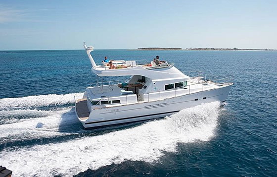 Power Lagoon 46 motor catamaran underway with guests on the flybridge, throwing a wake across the calm blue Caribbean off Cancun