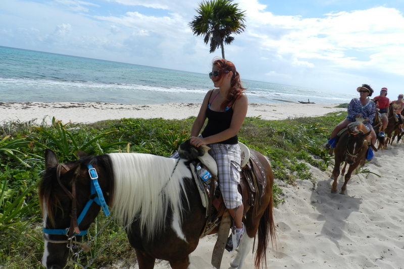 Horseback riders crossing the white sand of Maroma Beach near Playa del Carmen on a guided beach tour
