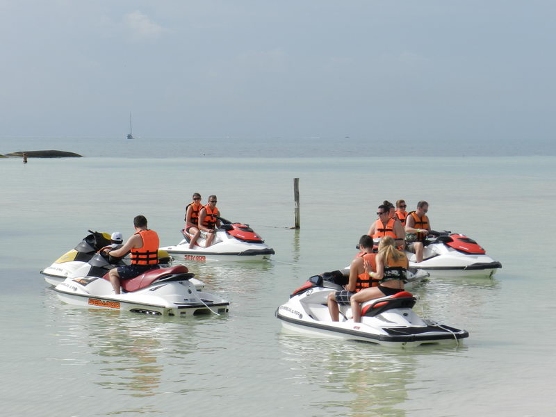 Group of guests in life vests riding wave runners on calm turquoise Caribbean water off Maroma beach, Riviera Maya