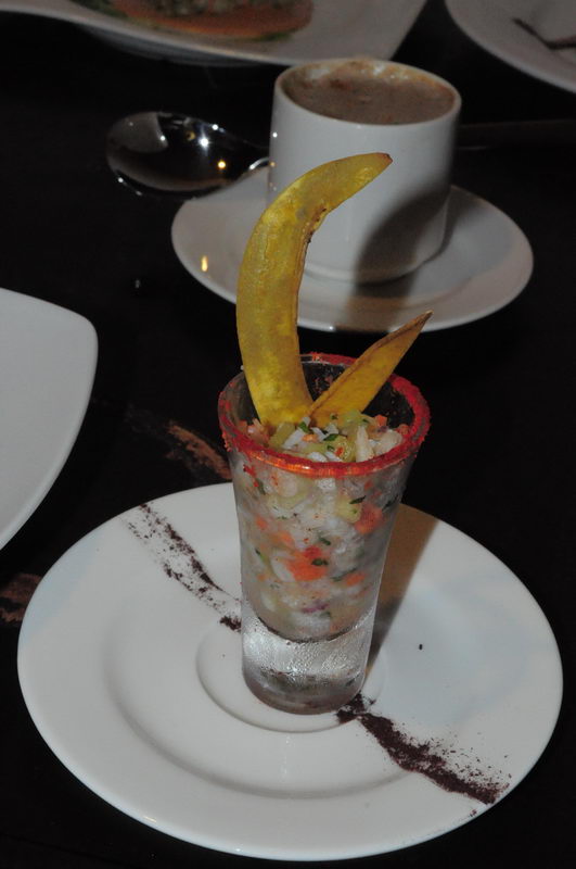 Seafood ceviche served in a tall chilled glass with crisp plantain chips, presented as a canape at a Maroma beach event