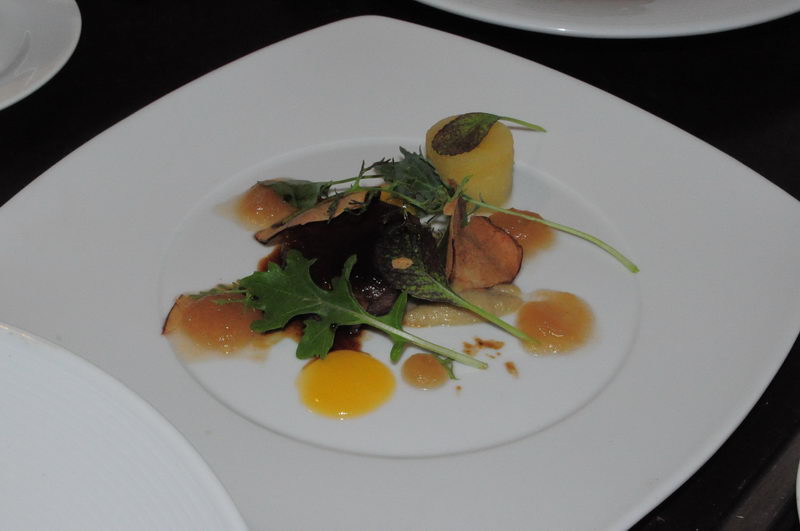 Artistically plated appetizer with arugula, beetroot, potato and dotted sauces on a white plate from the Maroma catering menu