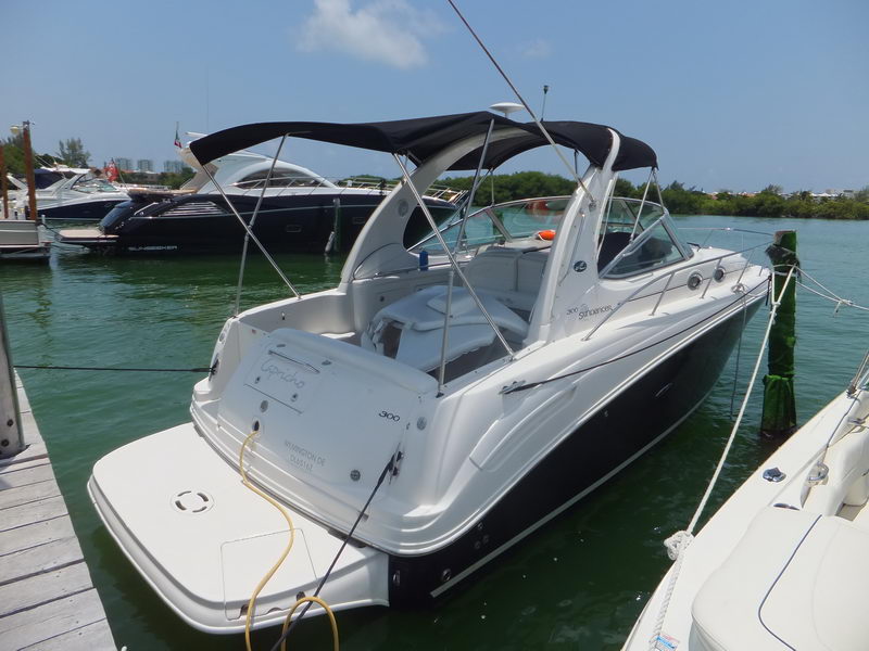 SeaRay Sundancer 300 sport yacht with bimini top docked at Cancun lagoon marina, available for luxury charter rental