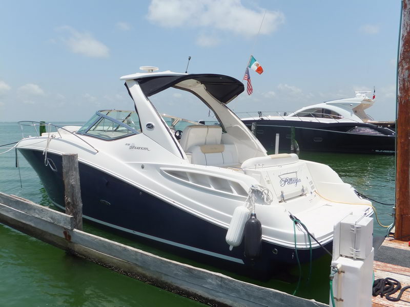 SeaRay Sundancer 330 luxury charter yacht Pellagia docked at Cancun marina, stern view with US and Mexican flags