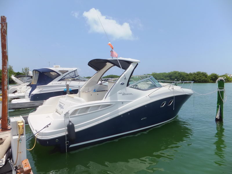 SeaRay Sundancer 338 luxury charter yacht moored at Cancun lagoon marina, elegant navy hull bow profile