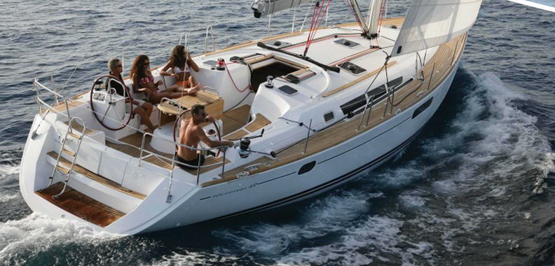 Group of guests in cockpit of Jeanneau Sun Odyssey 45 sailing at speed on open sea, luxury 