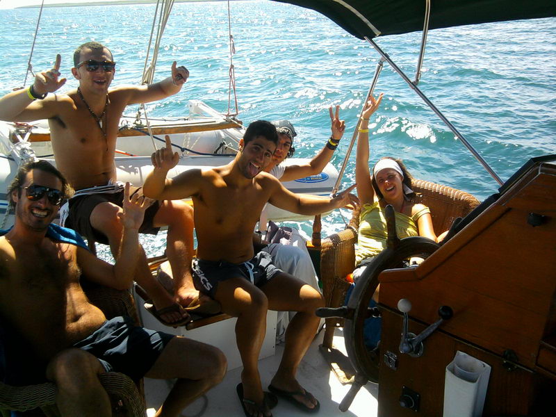 Happy group of friends posing in cockpit of 55 ft wooden ketch Calypsa, private Caribbean sailing charter Cancun party boat