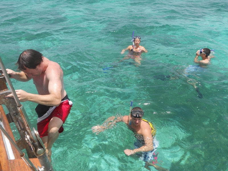 Guests aboard wooden ketch Calypsa enjoying private Caribbean cruise, historic 55 ft sailboat charter Cancun Mexico