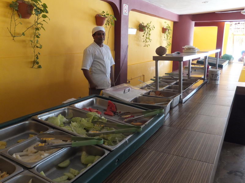 Chef serving the fresh buffet line at the Isla Mujeres beach club restaurant included in the Samba catamaran tour lunch