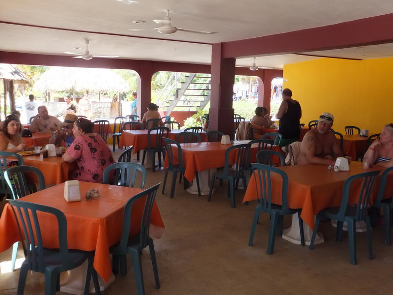 Visitors relaxing over lunch in the shaded beachfront restaurant at Isla Mujeres, part of the all-inclusive Samba catamaran tour