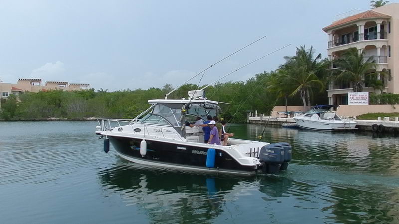 fishing charter boat with rods rigged cruising Puerto Aventuras marina Riviera Maya